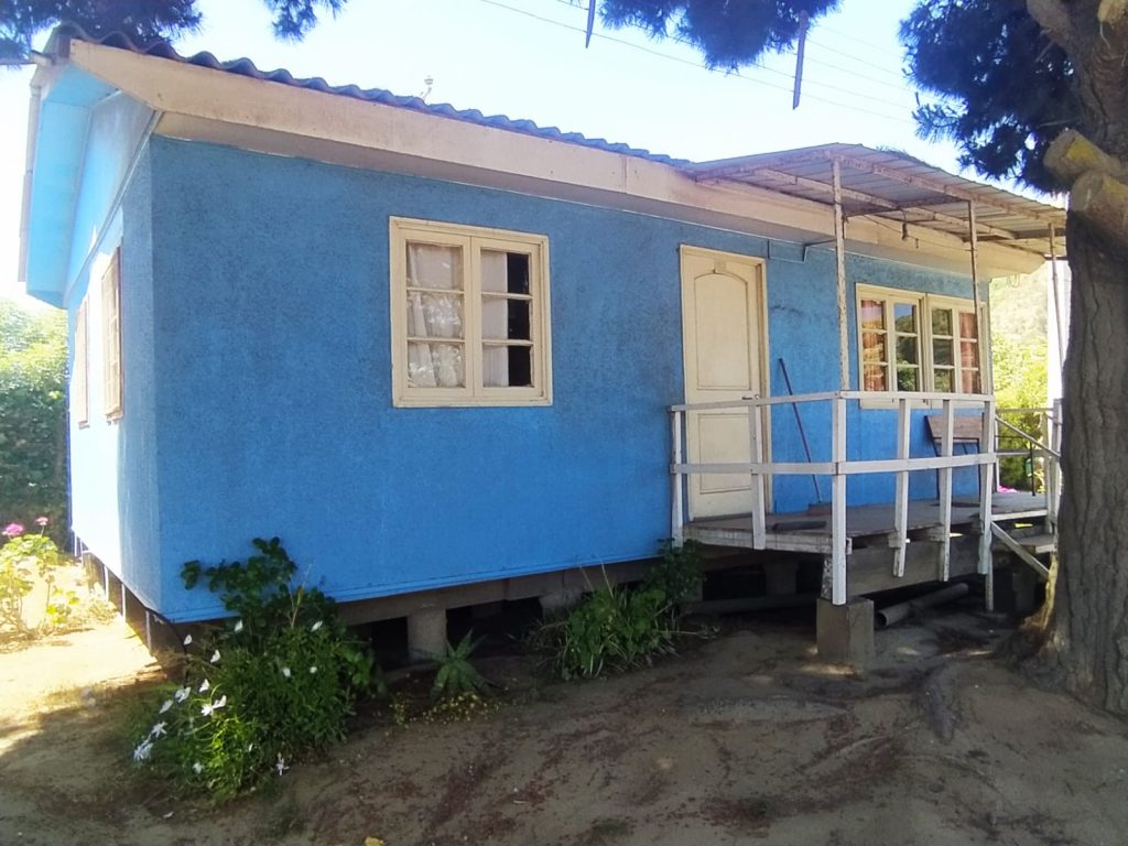 Casa azul con porche y jardín.